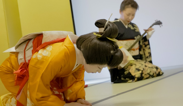 A geisha performing with a shamisen