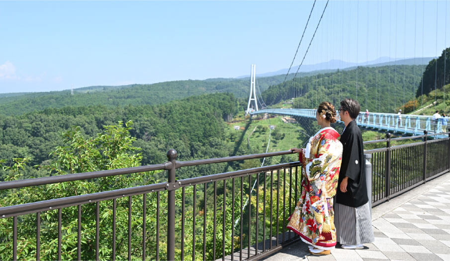 A couple in kimono enjoys Mount Fuji's view from the bridge