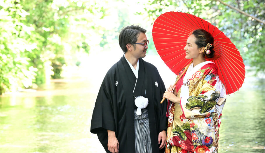 A couple in kimono shine by the lush Genbe River