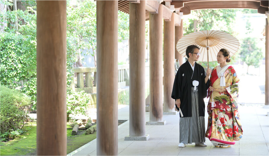 A couple in kimono walks through the corridor a Mishima Grand Shrine