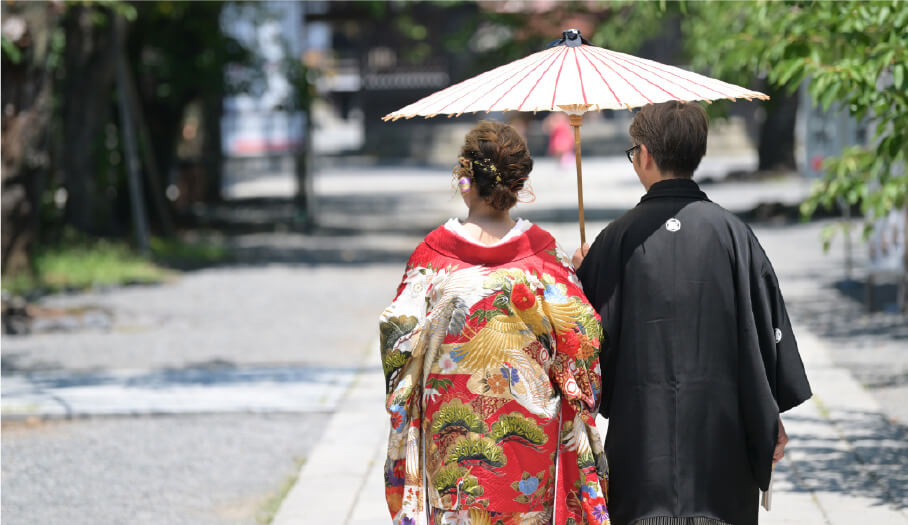 A couple strolls in kimono under a parasol at Mishima Grand Shrine