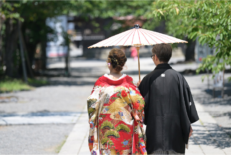 A couple strolls in kimono under a parasol at Mishima Grand Shrine