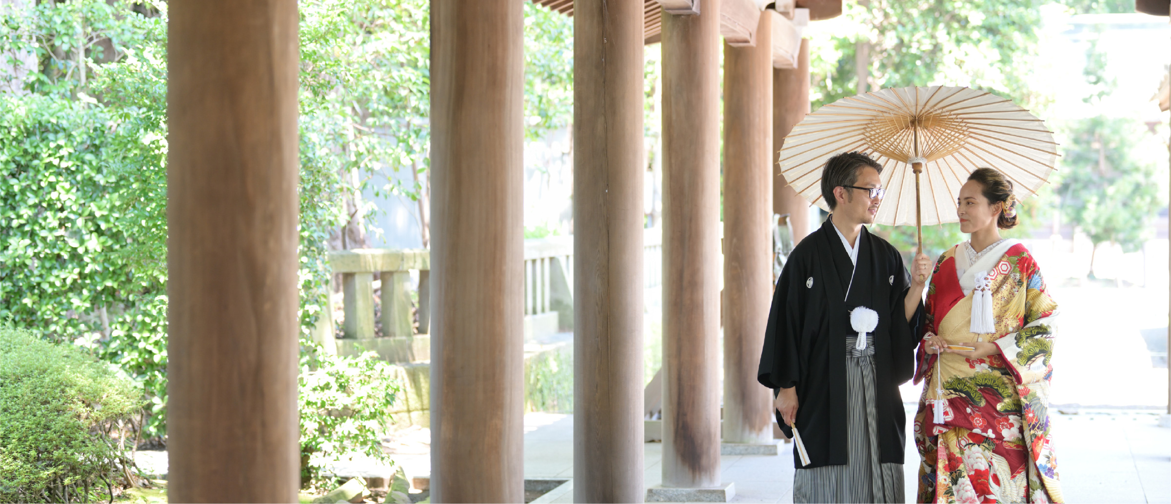 A couple in kimono walks through the corridor a Mishima Grand Shrine