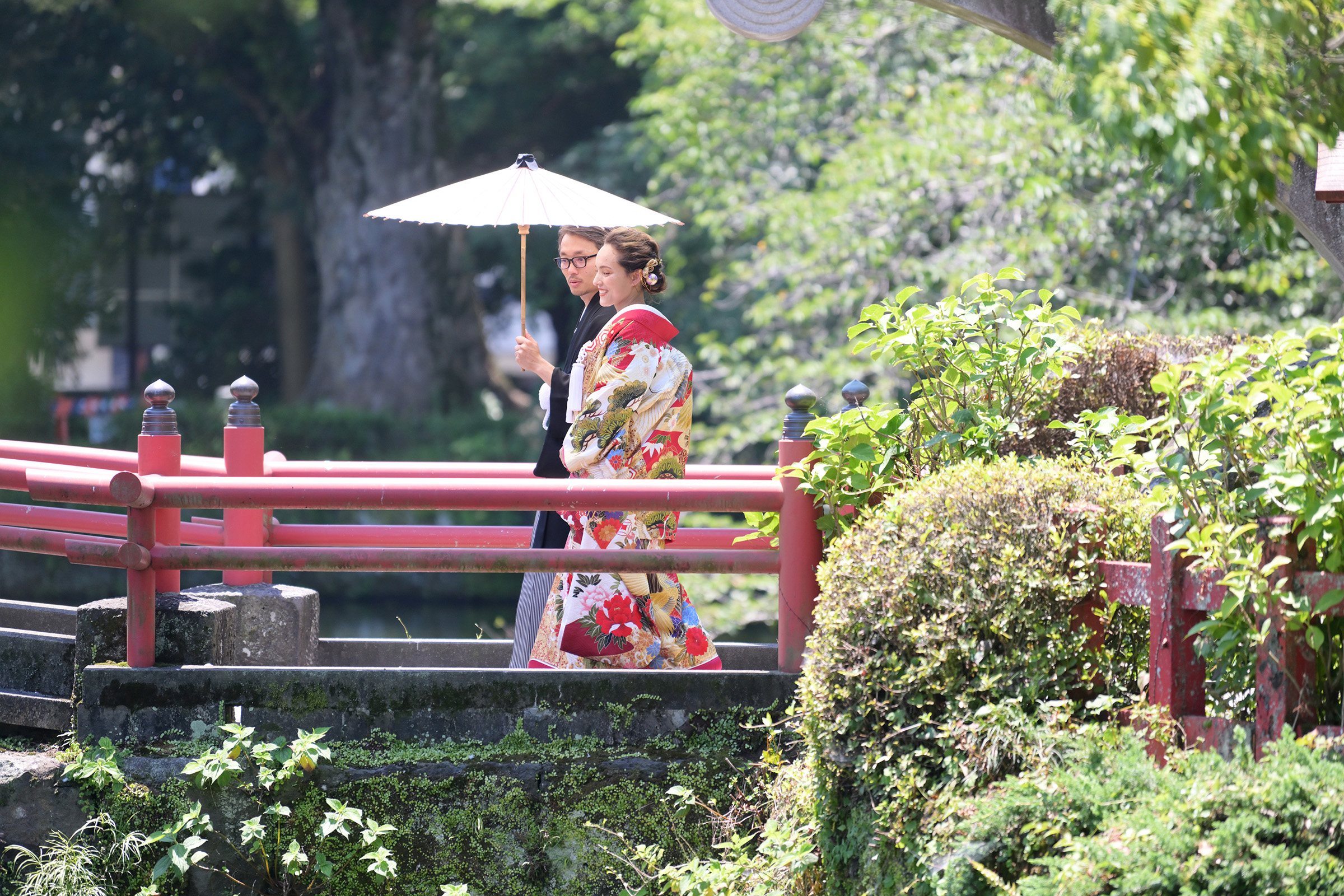 A couple dressed in a traditional Japanese kimono, walking through a bridge