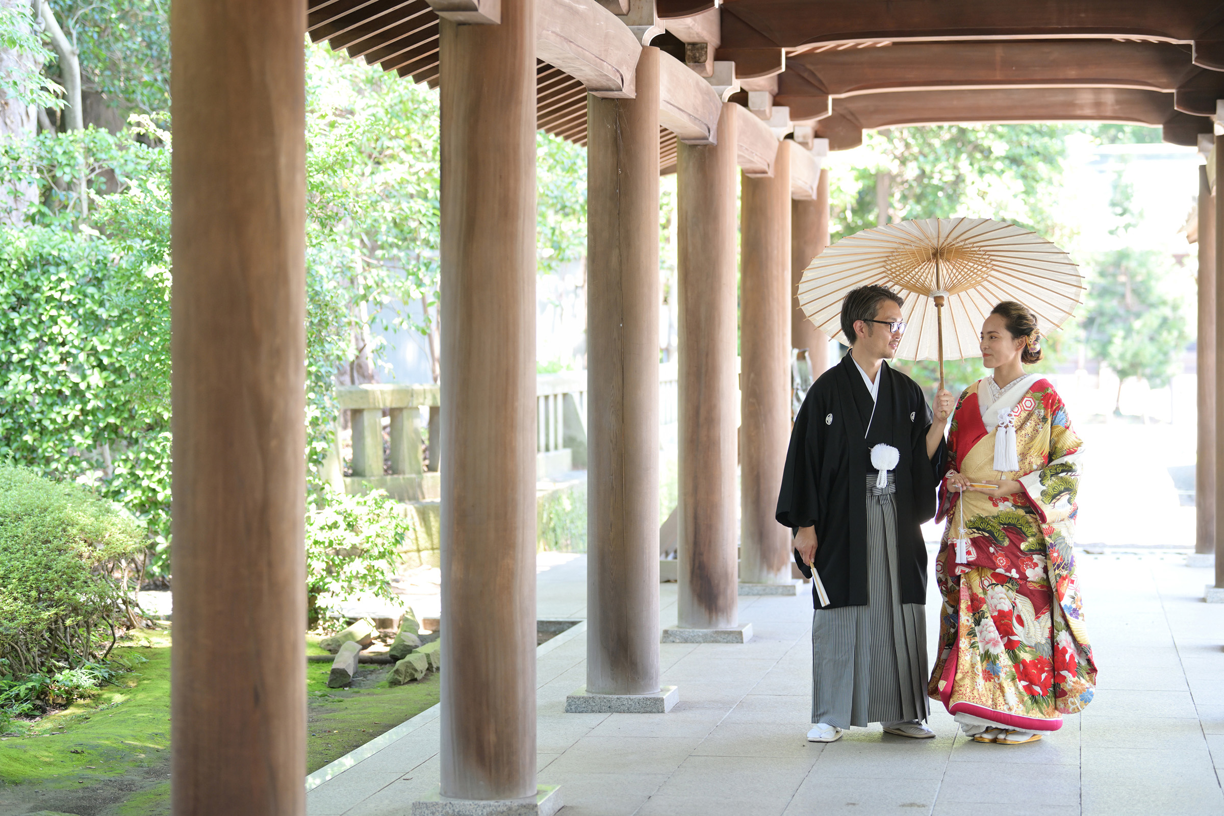 A couple in kimono walks through the corridor a Mishima Grand Shrine