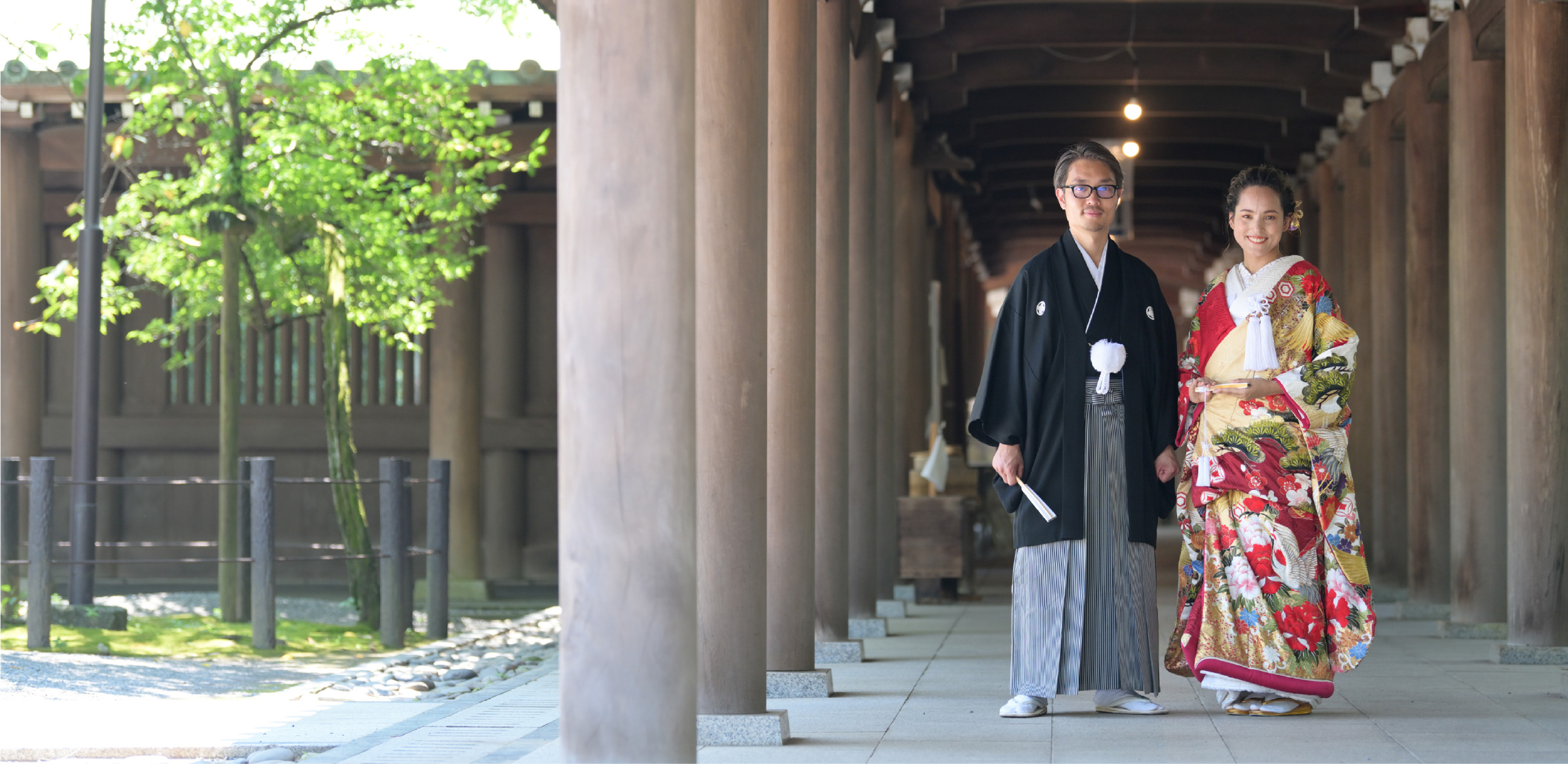 A couple in traditional Japanese kimono walking through Mishima Grand Shrine corridor