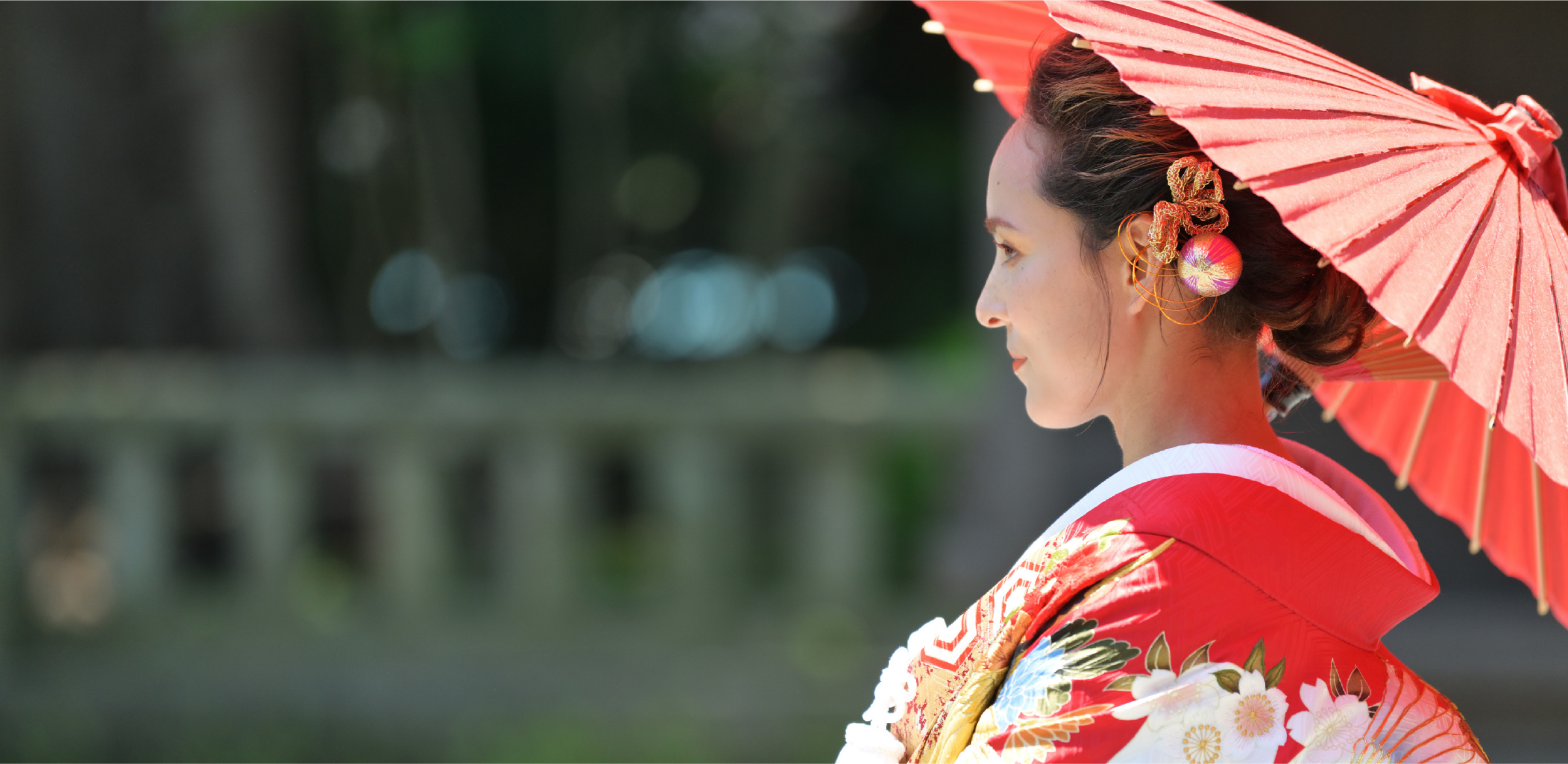 A woman dressed in a traditional Japanese kimono holding traditional parasol